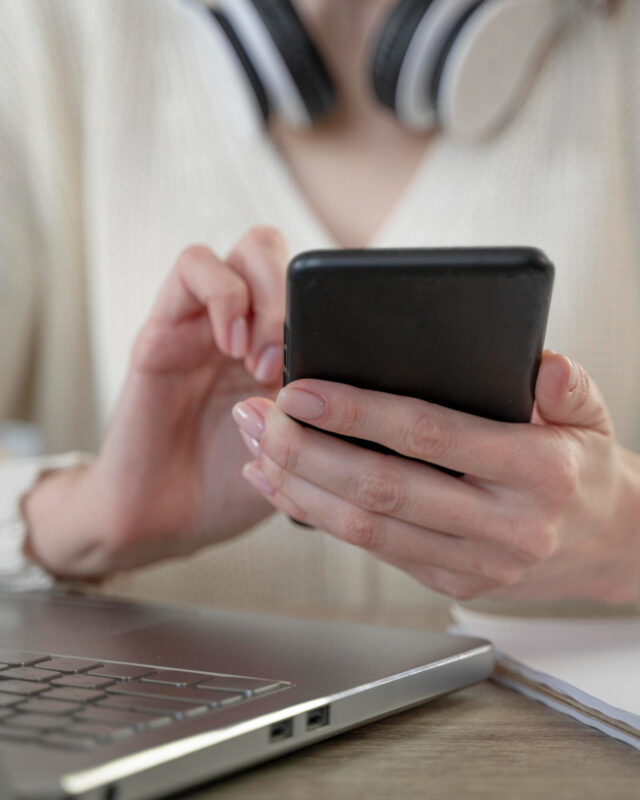 close up woman using smartphone laptop